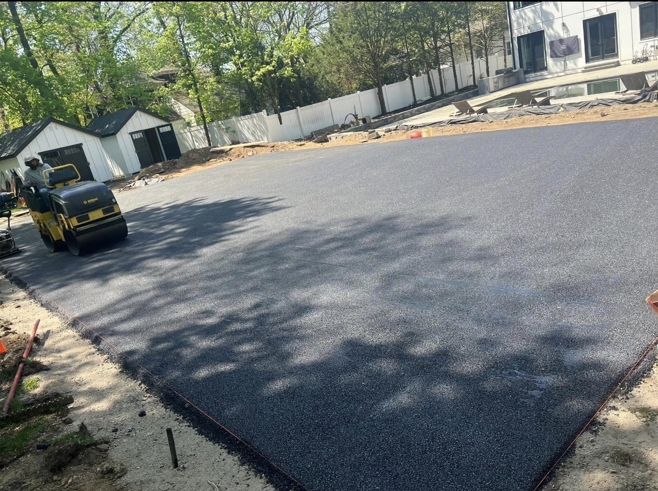 Fresh asphalt parking pad with steamroller — NJ